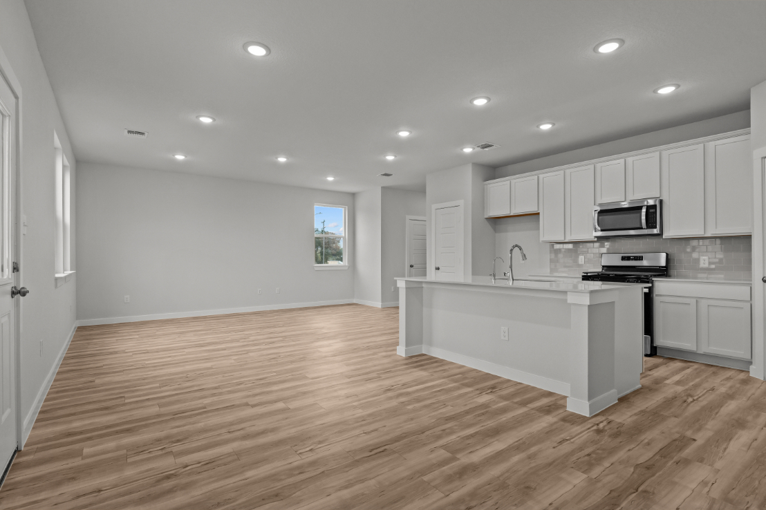 A kitchen with white cabinets.