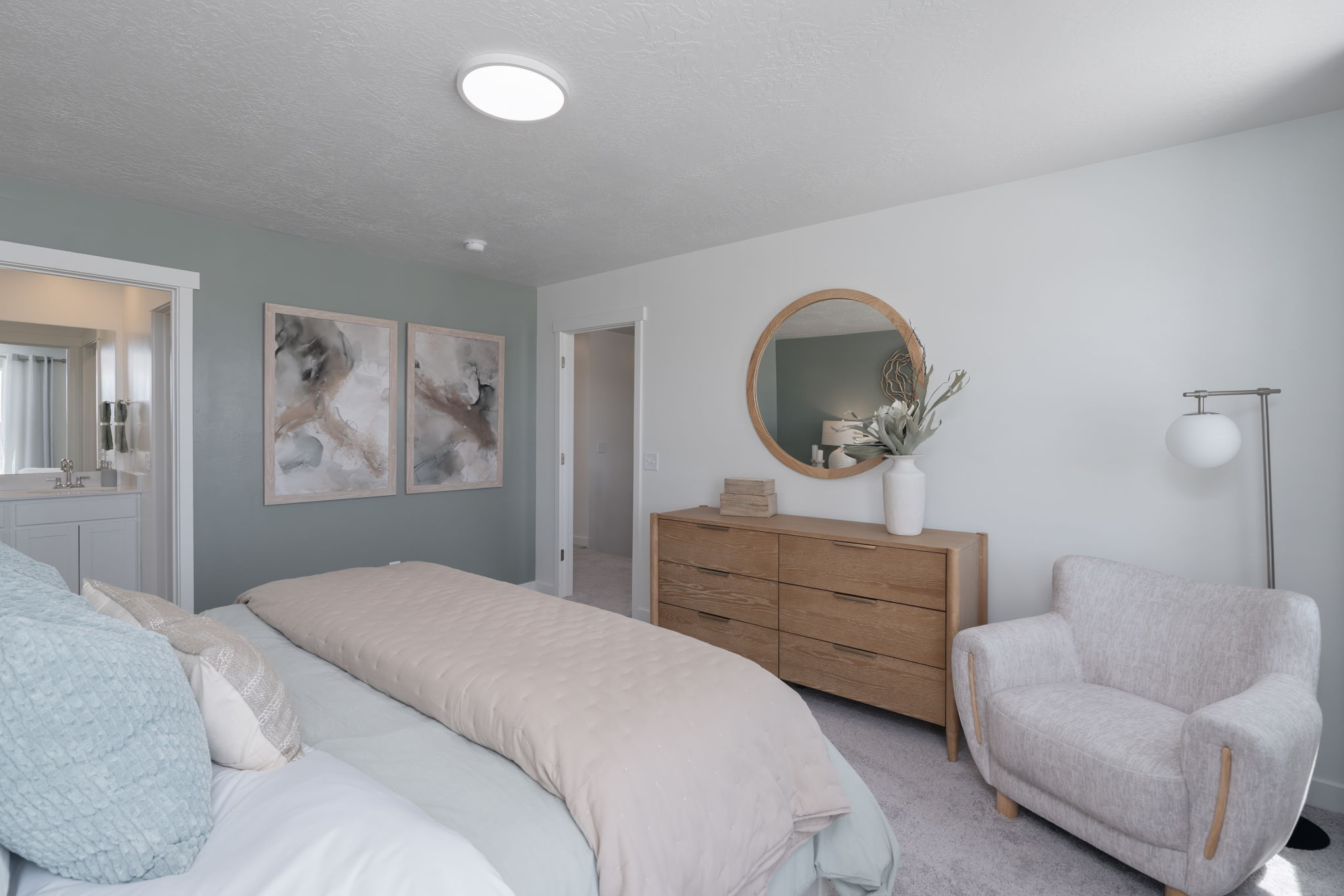 A bedroom with a bed and a chair.