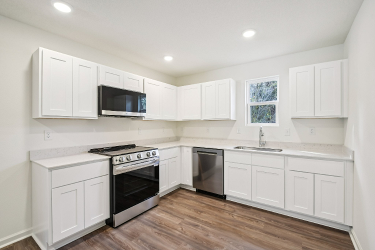 A kitchen with white cabinets.