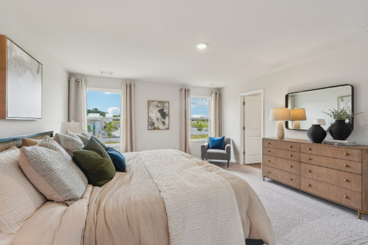 A bedroom with a bed and dresser.