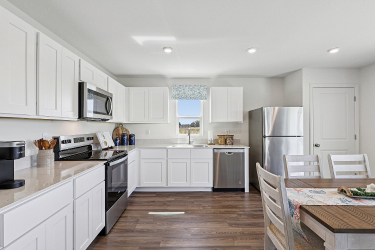 A kitchen with white cabinets.