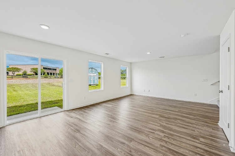 A room with a wood floor and a wood floor with a window.