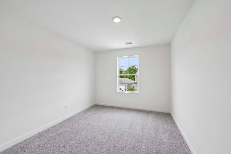 A room with a window and a carpet.