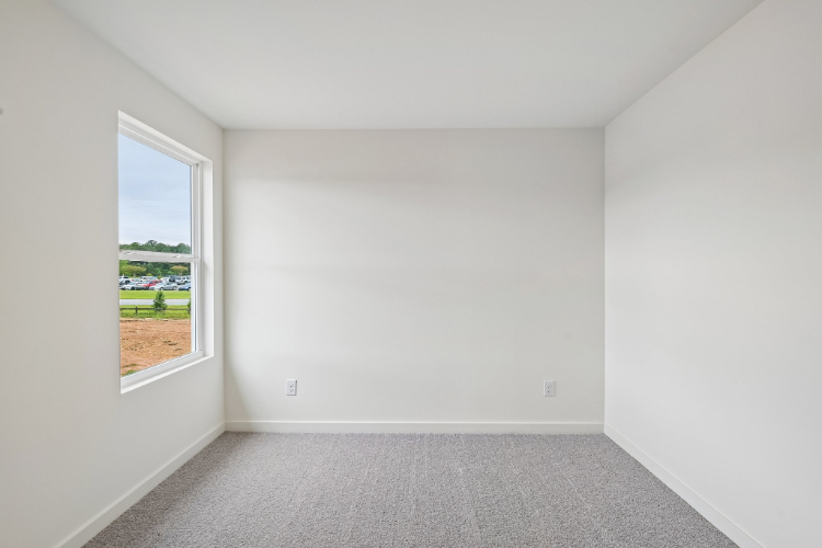 A room with a window and a carpet.