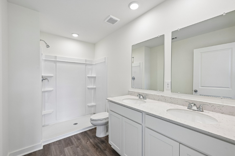 A bathroom with a toilet sink and mirror.