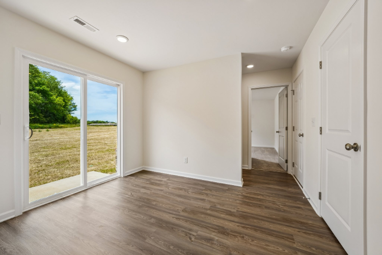 A room with a wood floor and a large window.