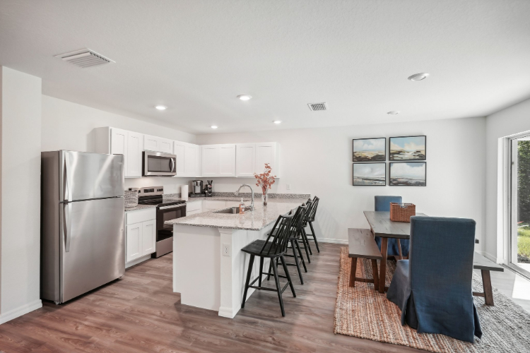 A kitchen with a dining table and chairs.