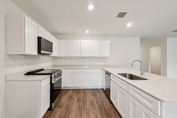 A kitchen with white cabinets.