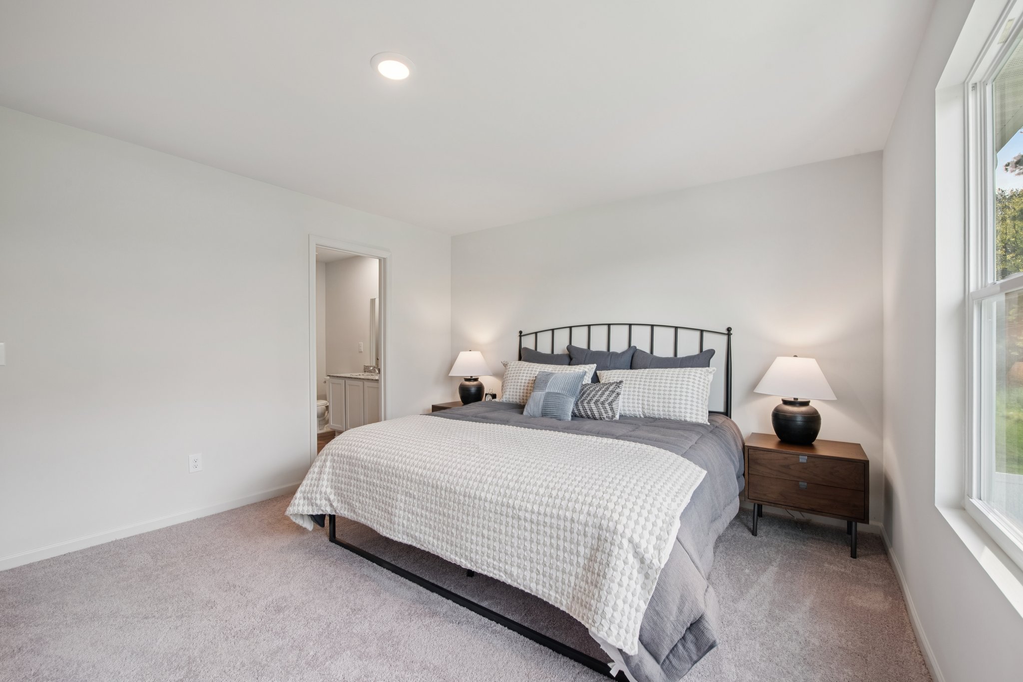 A bedroom with a bed and lamps.