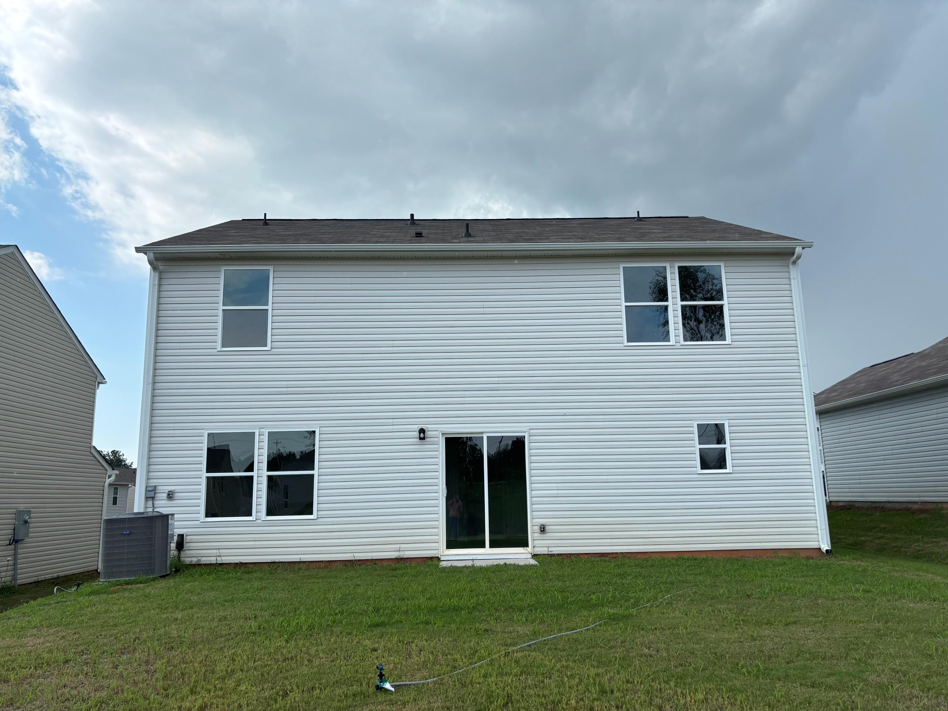 A grey house with a grass yard.