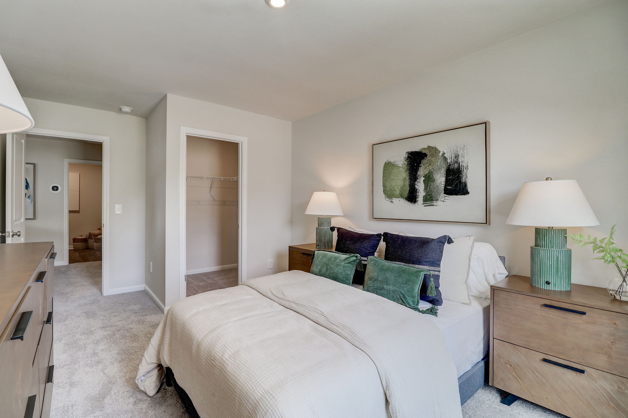 A bedroom with a bed and lamps.